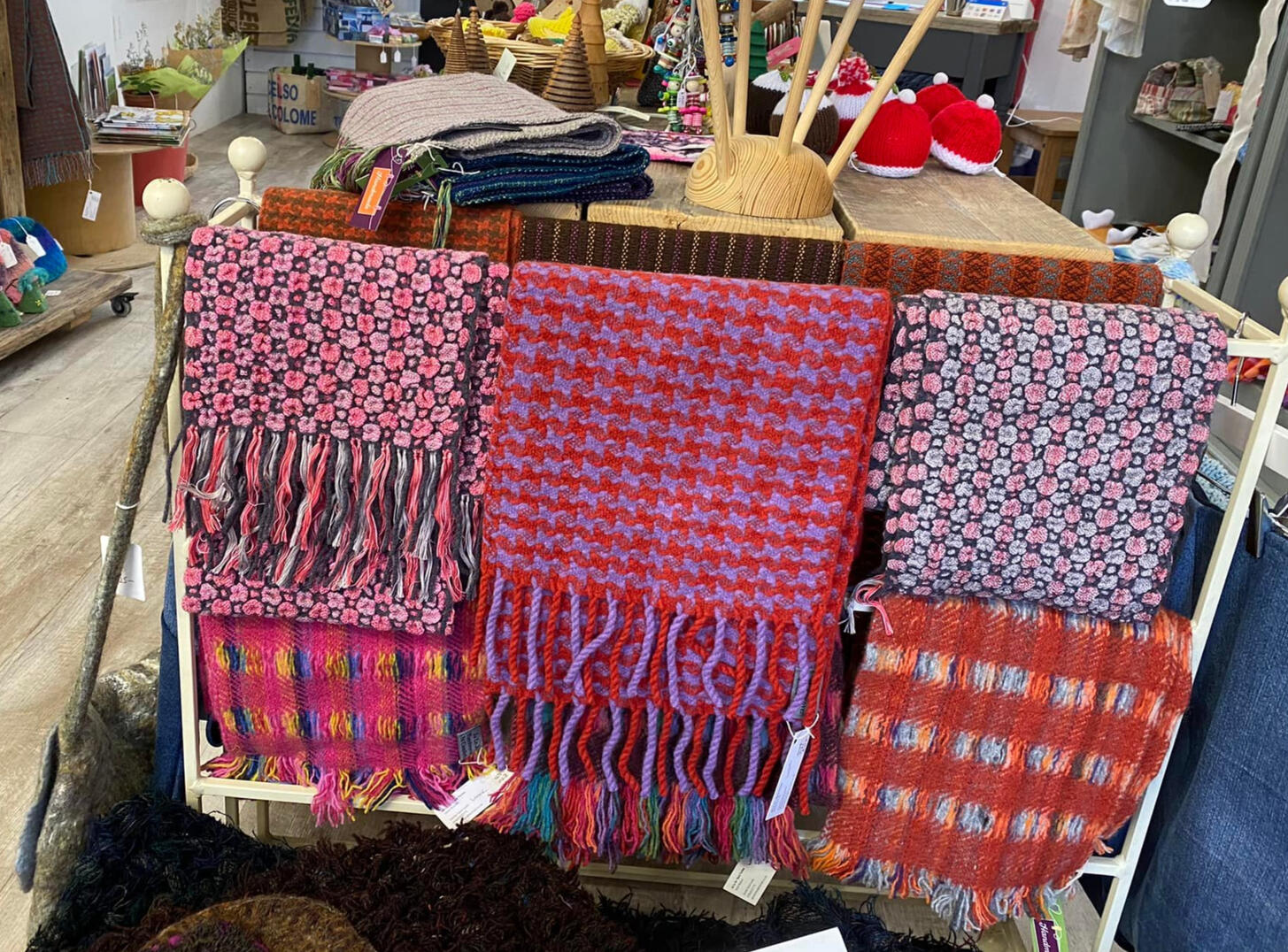 Display of multiple handwoven scarves at a craft stall – JaLoJo textile showcase